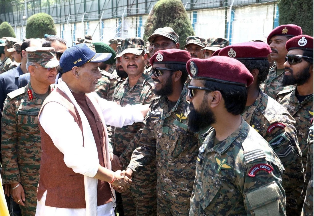 Maroon-beret special forces personnel being greeted and congratulated with handshakes by a dignitary